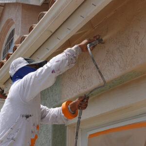 Professional contractor using a spray paint gun to paint the stu